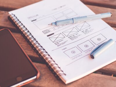 Τετράδιο με σκίτσα wireframe δίπλα σε κινητό