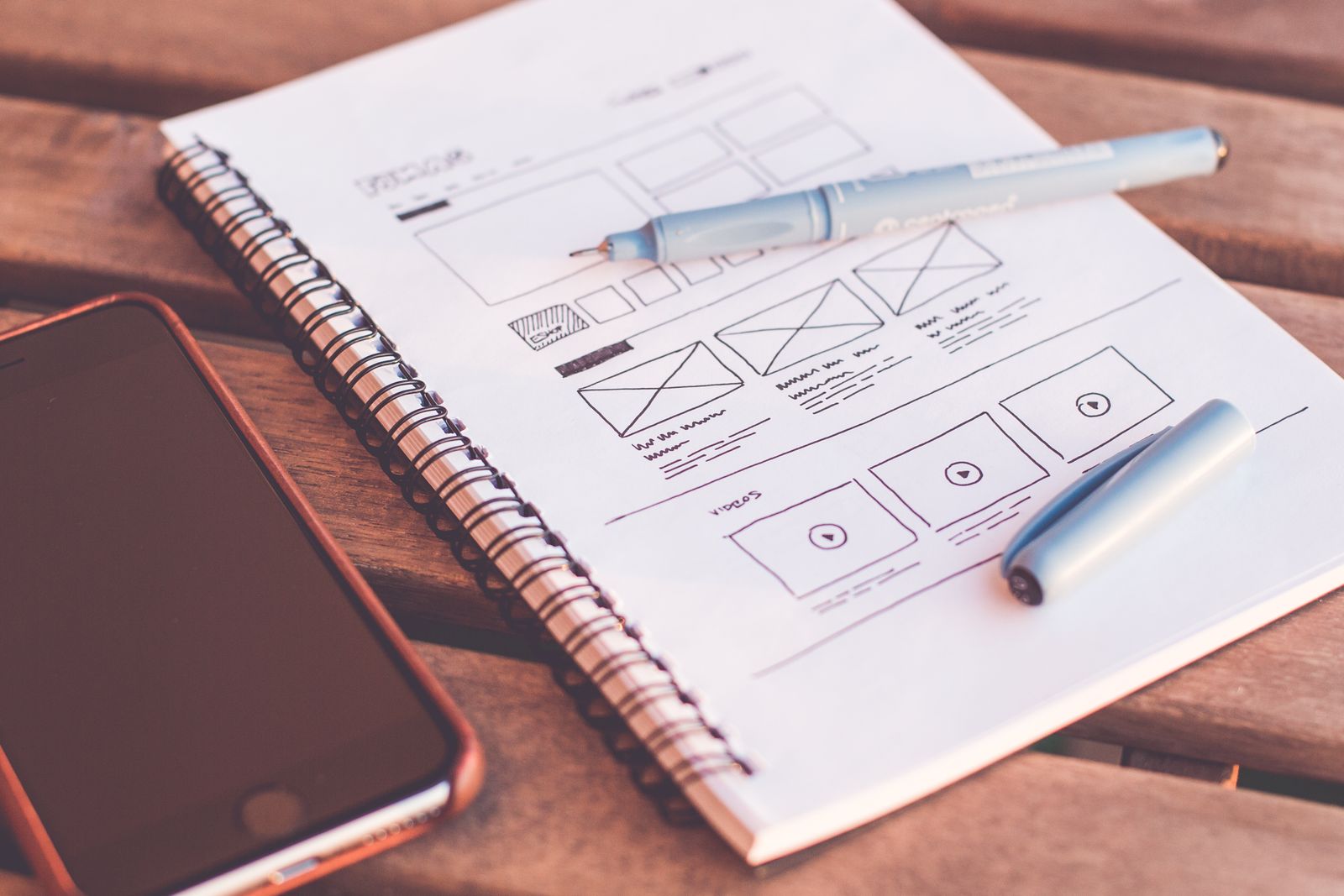 Τετράδιο με σκίτσα wireframe δίπλα σε κινητό
